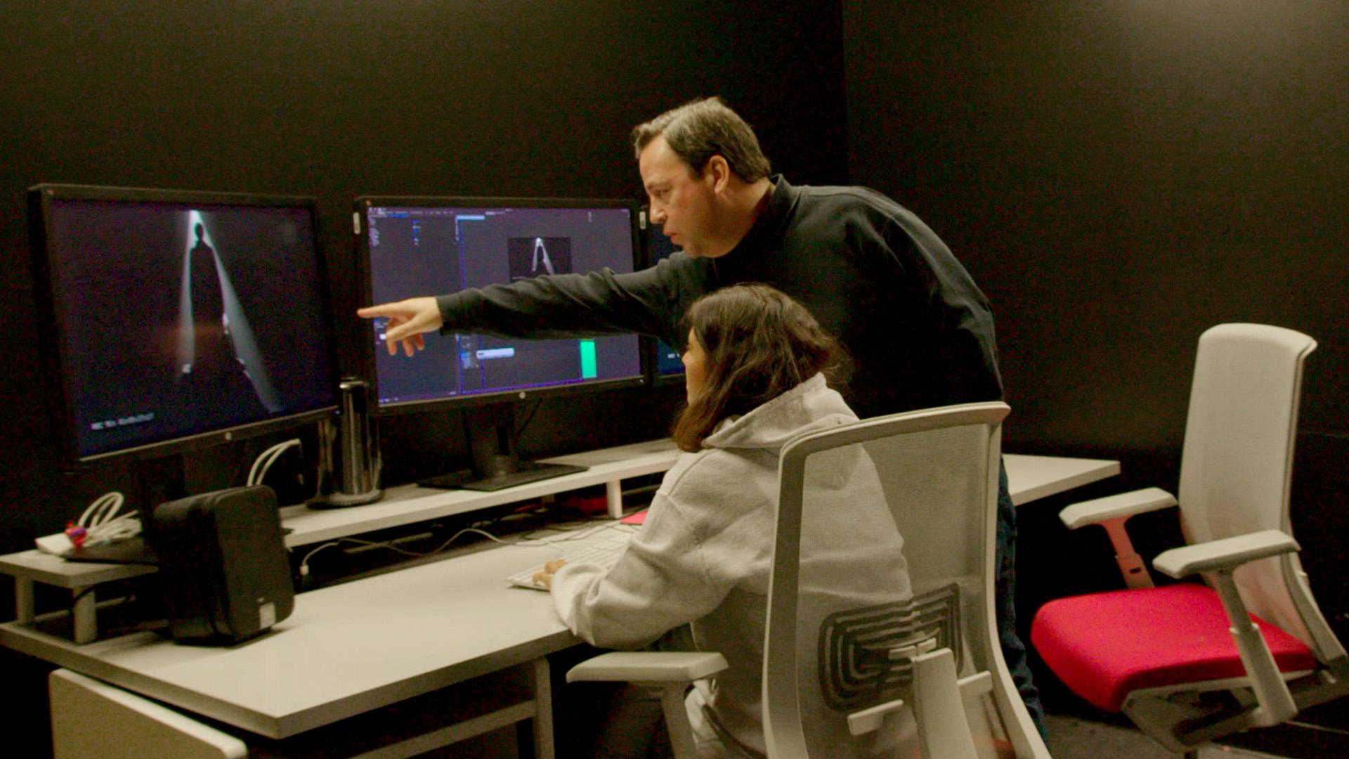 Male and female college students sitting in front of a computer.